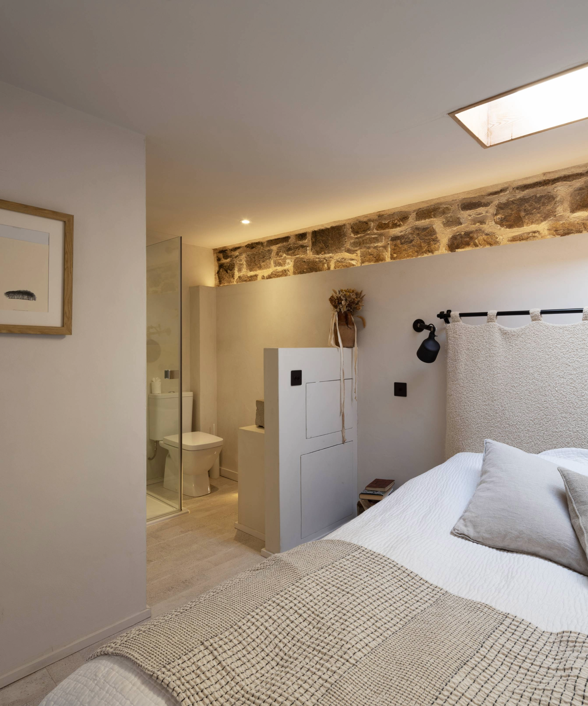 Bedroom with roof light, exposed brick, and en suite