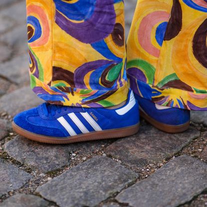 A guest wears royal blue suede sneakers from Adidas , outside Helmstedt, during the Copenhagen Fashion Week Autumn/Winter 2023 on February 02, 2023 in Copenhagen, Denmark