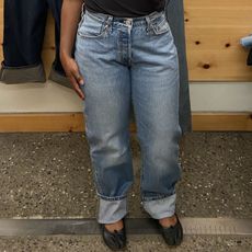 a woman wearing blue jeans and black flats