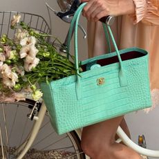 A picture of a mint blue Chanel bag with a bouquet of flowers in