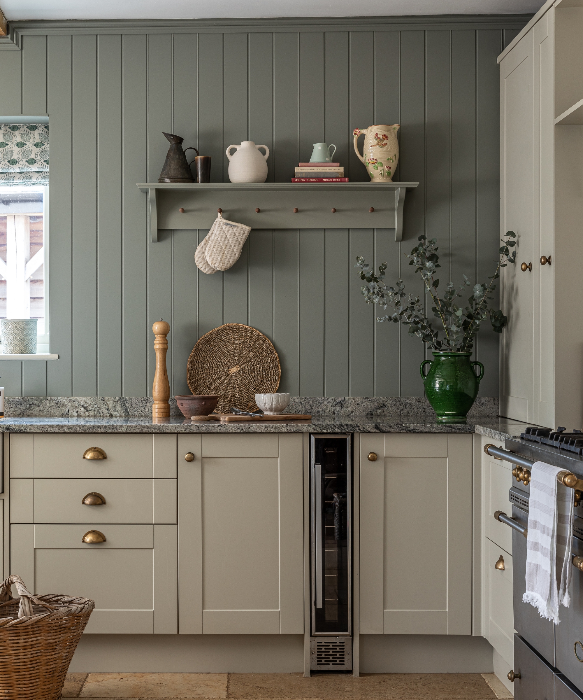 A small country kitchen with cabinets painted in Old White by Farrow &amp;amp; ball and paneled walls painted in Pigeon by Farrow &amp;amp; Ball