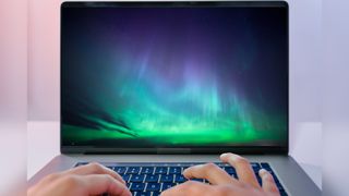 graphic showing two hands typing on a laptop screen with a large image of the northern lights on the screen.