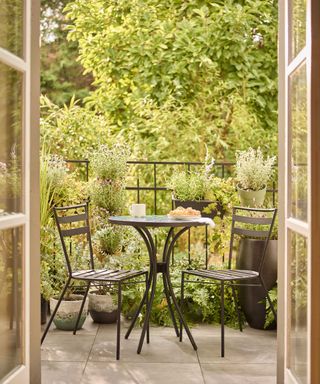 Dobbies balcony garden with bistro set and potted plants