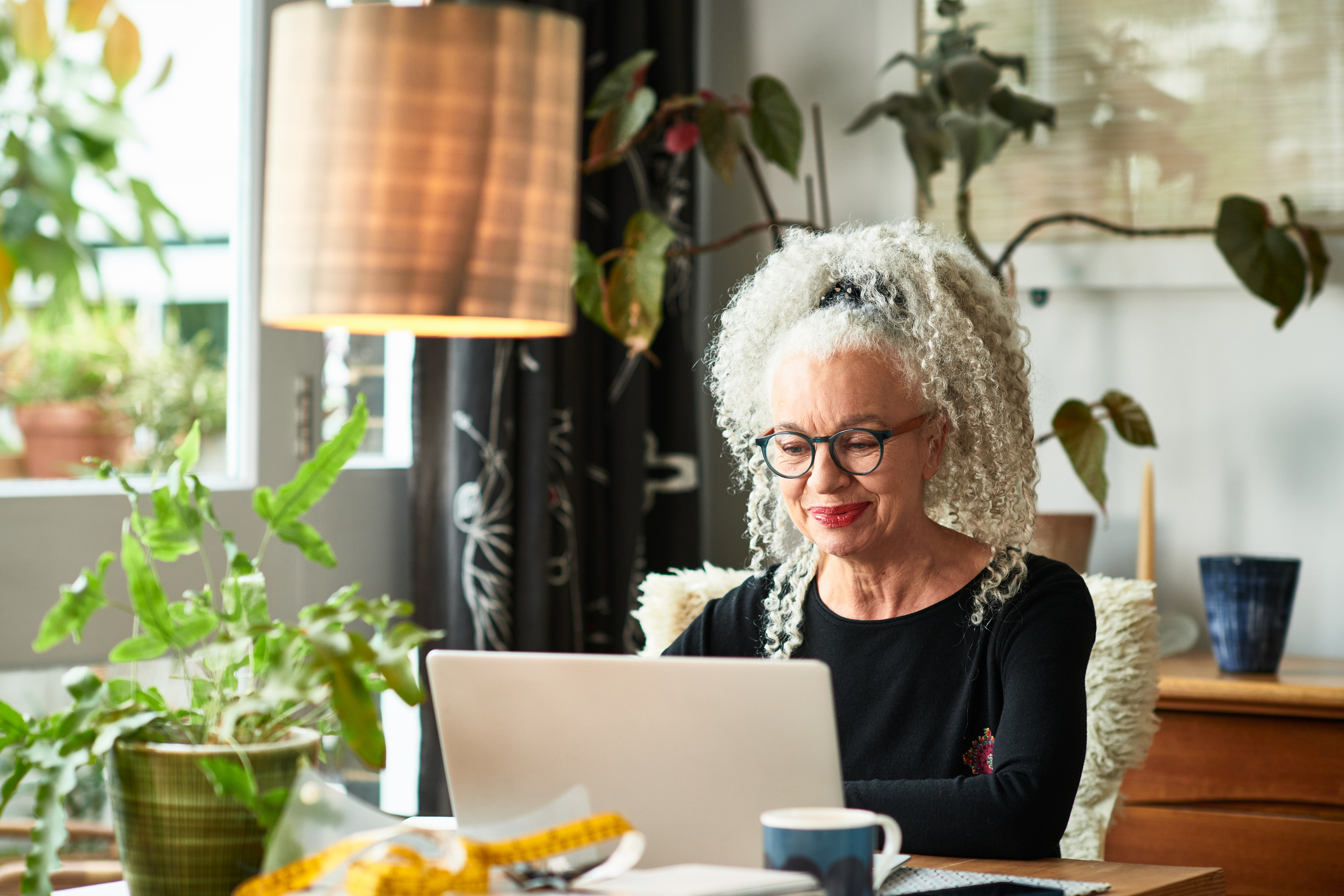 Woman at home smiling in front of laptop