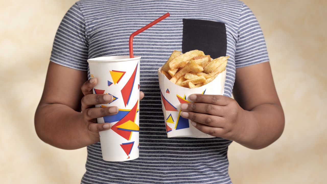 Child holding fries and soda