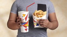 Child holding fries and soda