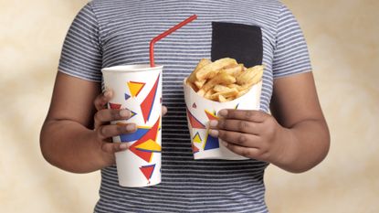 Child holding fries and soda