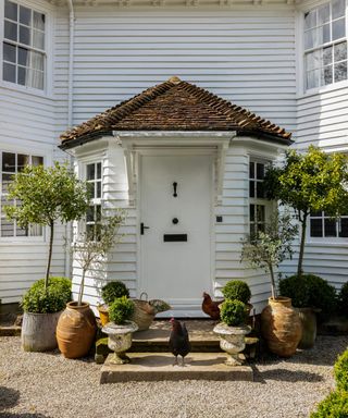 white panelled home with rustic front door