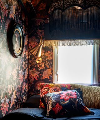 cosy bedroom corner with dark floral wallpaper, bedding and fringed pendant light