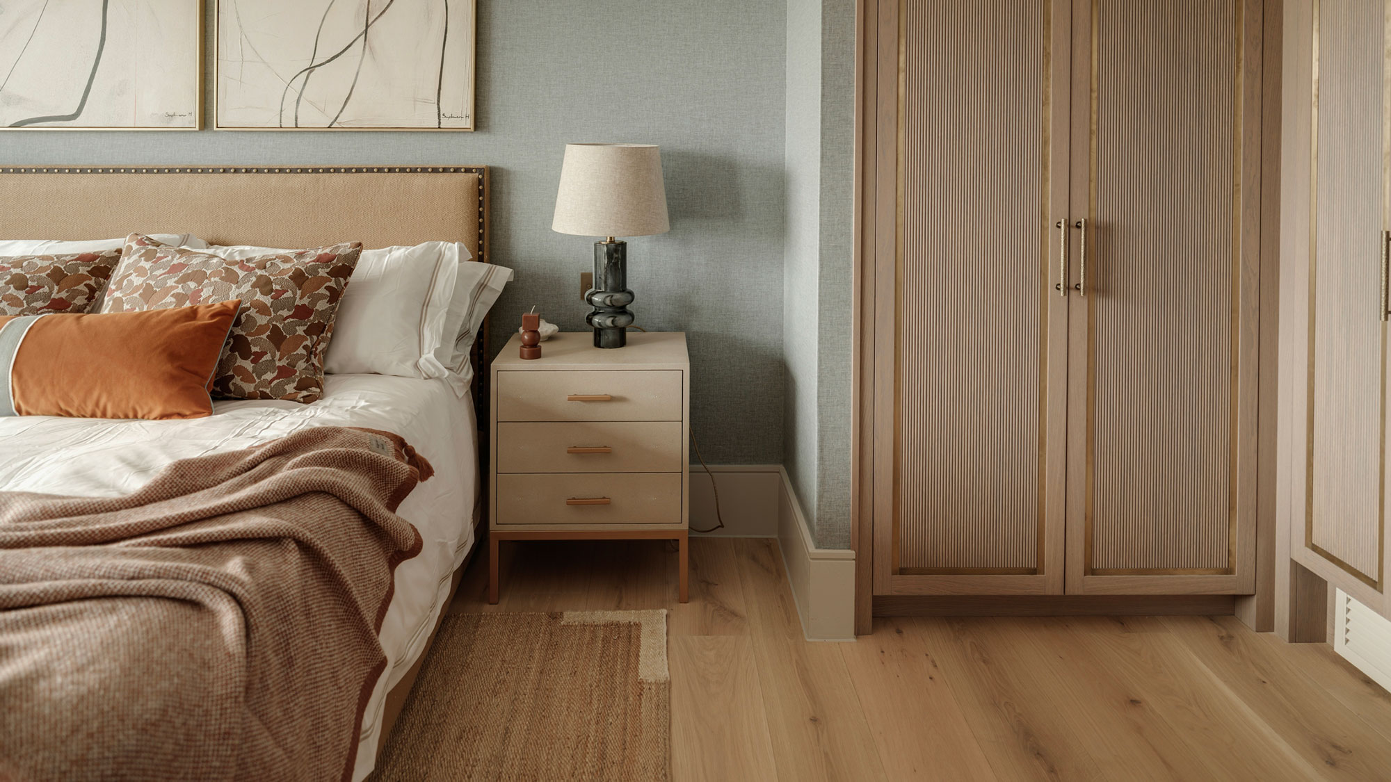 bedroom with engineered wood flooring and fitted wardrobes
