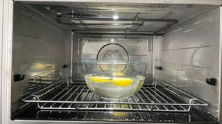 a bowl of lemon and water in a dirty microwave