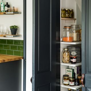 kitchen with white shelves and navy blue door