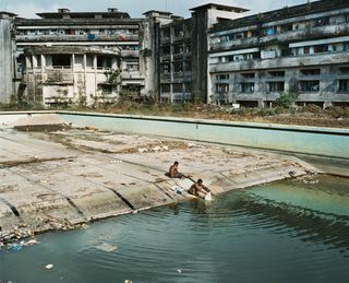 People washing their clothes in the swimming pool of The Grande,