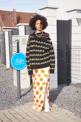Meryll Rogge A/W 2021 model wears knitted jumper and daisy print skirt