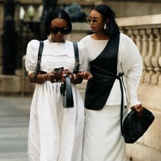 Women in white dresses looking at their phone