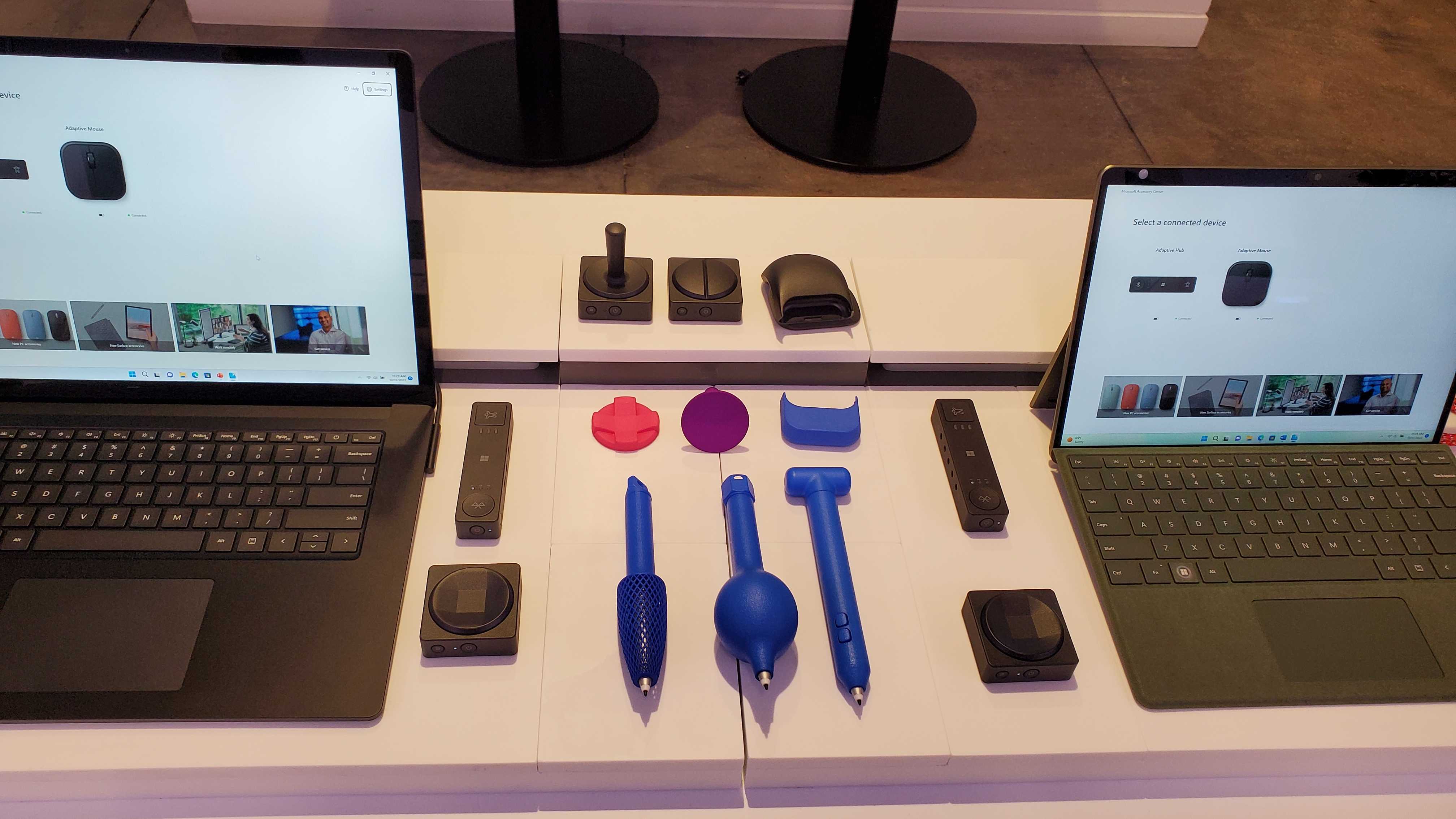 A selection of new Microsoft Adaptive Accessories laid out between two Surface products.