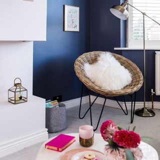 room with blue wall and chair and cushion and lamp