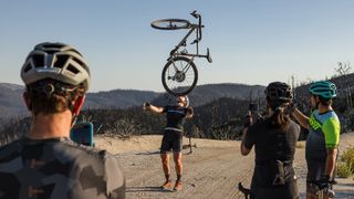 A person balances a gravel bike on their head while wearing the Leatt MTB Endurance & Gravel range