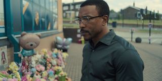 ashley waters as detective Inspector Bascombe walking outside of the school with a memorial set up in the tv show adolescence