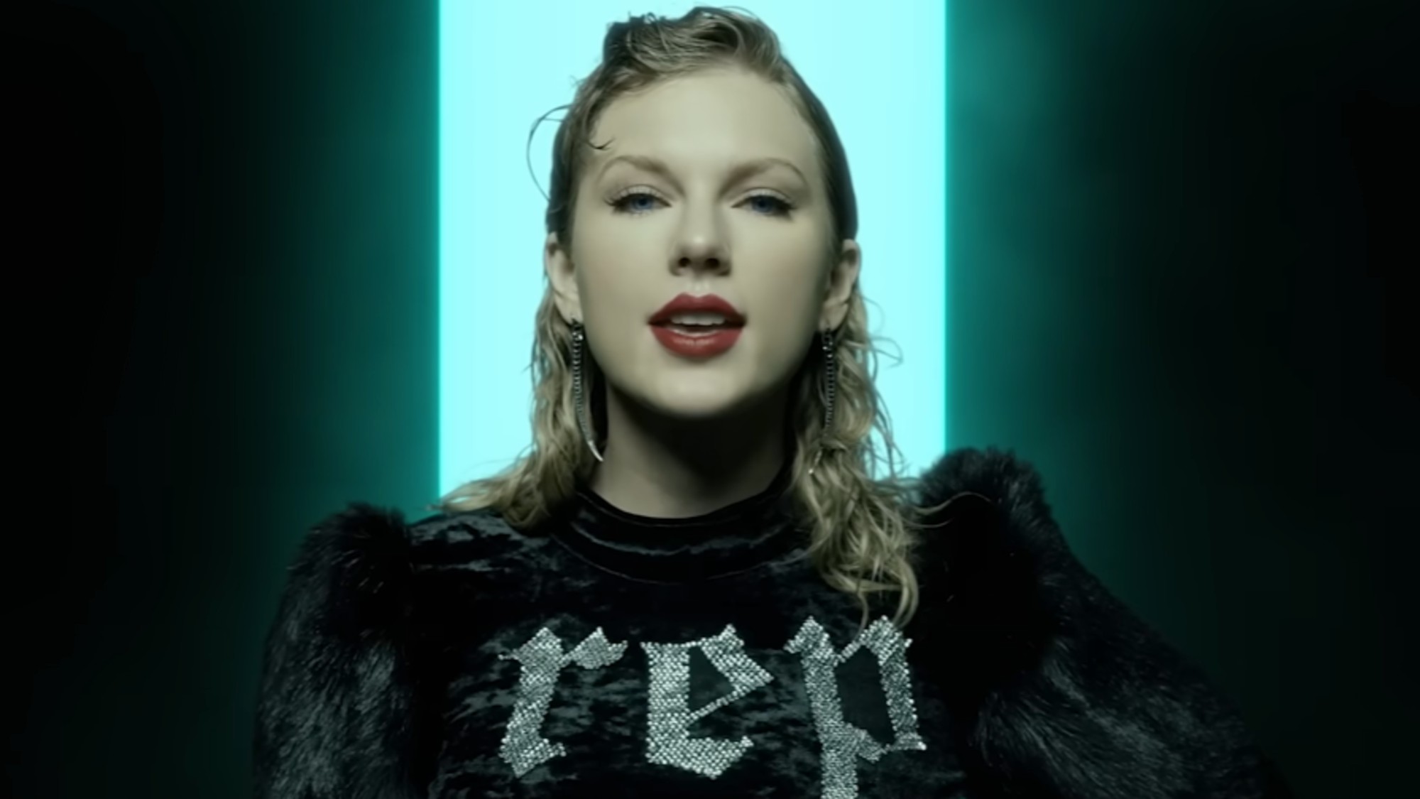 Taylor Swift wearing a top that says "Rep" in the "Look What You Made Me Do" music video.