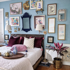 blue bedroom with eclectic gallery wall behind headboard