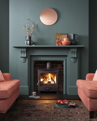teal chimney and fireplace with stove in the chimney flanked by salmon sofas