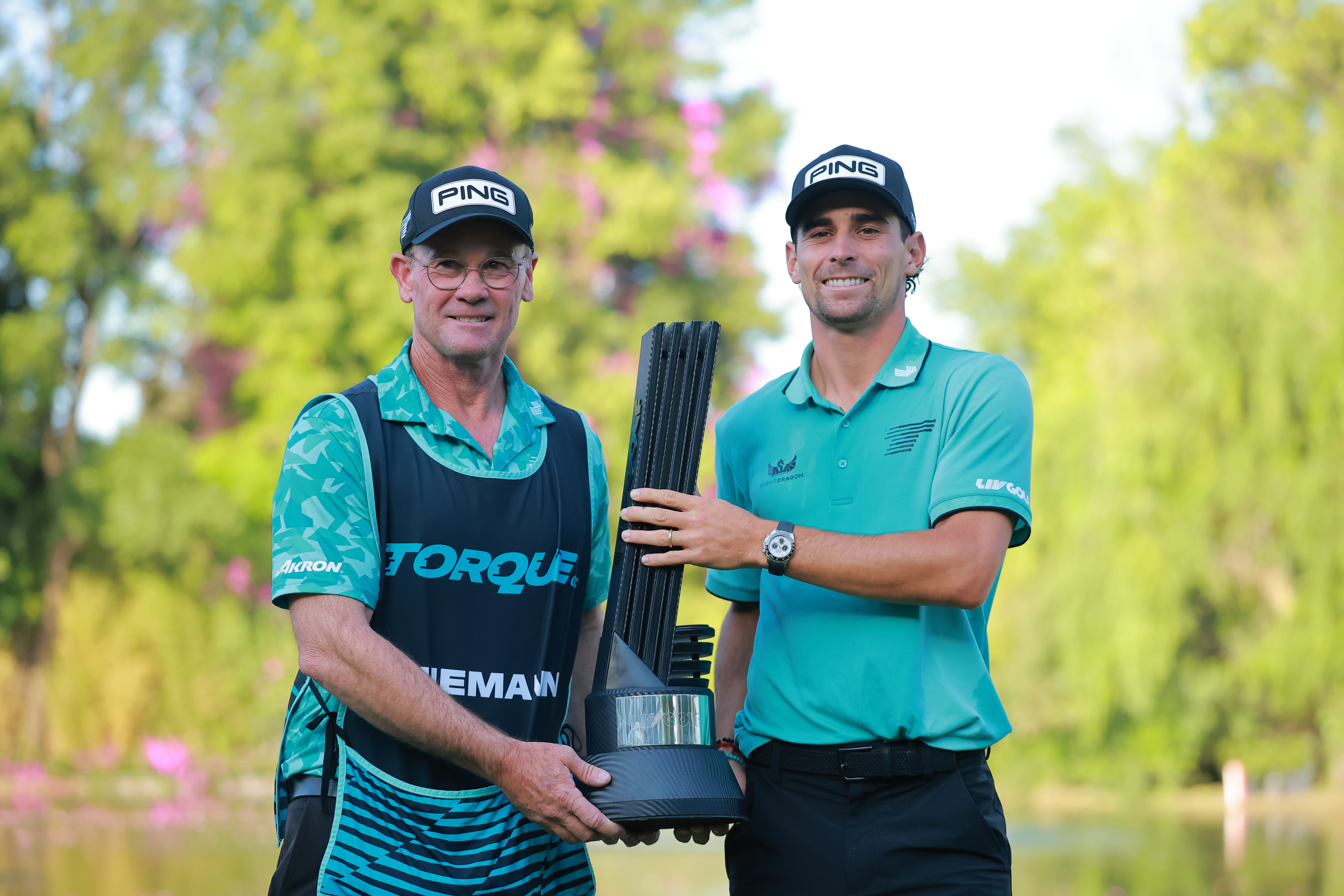 Gary Matthews and Joaquin Niemann holds a LIV Golf trophy