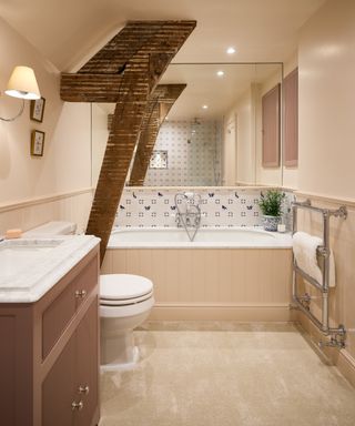 bathroom with large mirrored wall above bath and exposed bean and strut