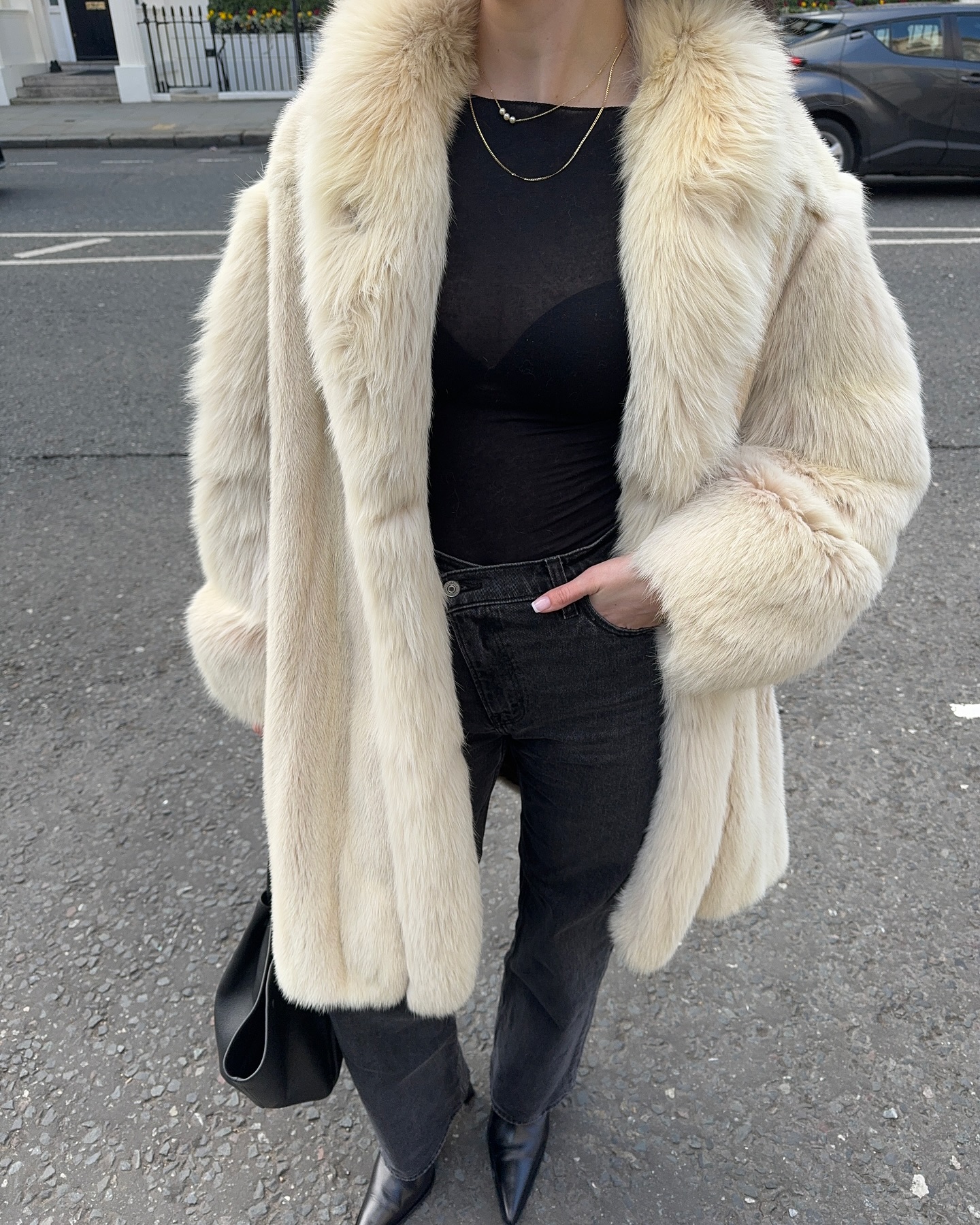 Street style photo of woman wearing a long fur coat.