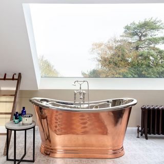 attic bathroom with copper bathtub and radiator