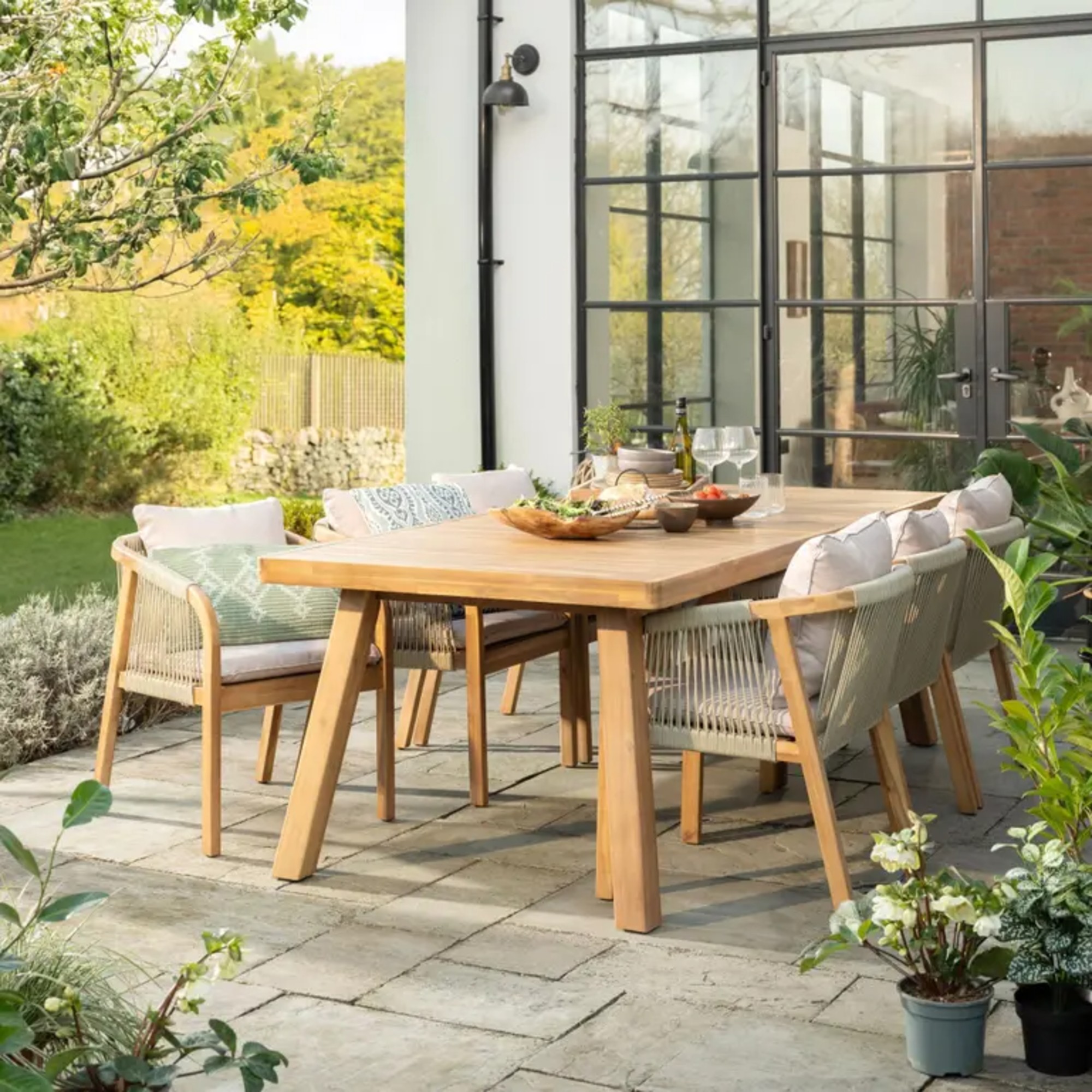 Barker and Stonehouse Tavira Teak Wood Garden Table and Rope Chairs on a patio