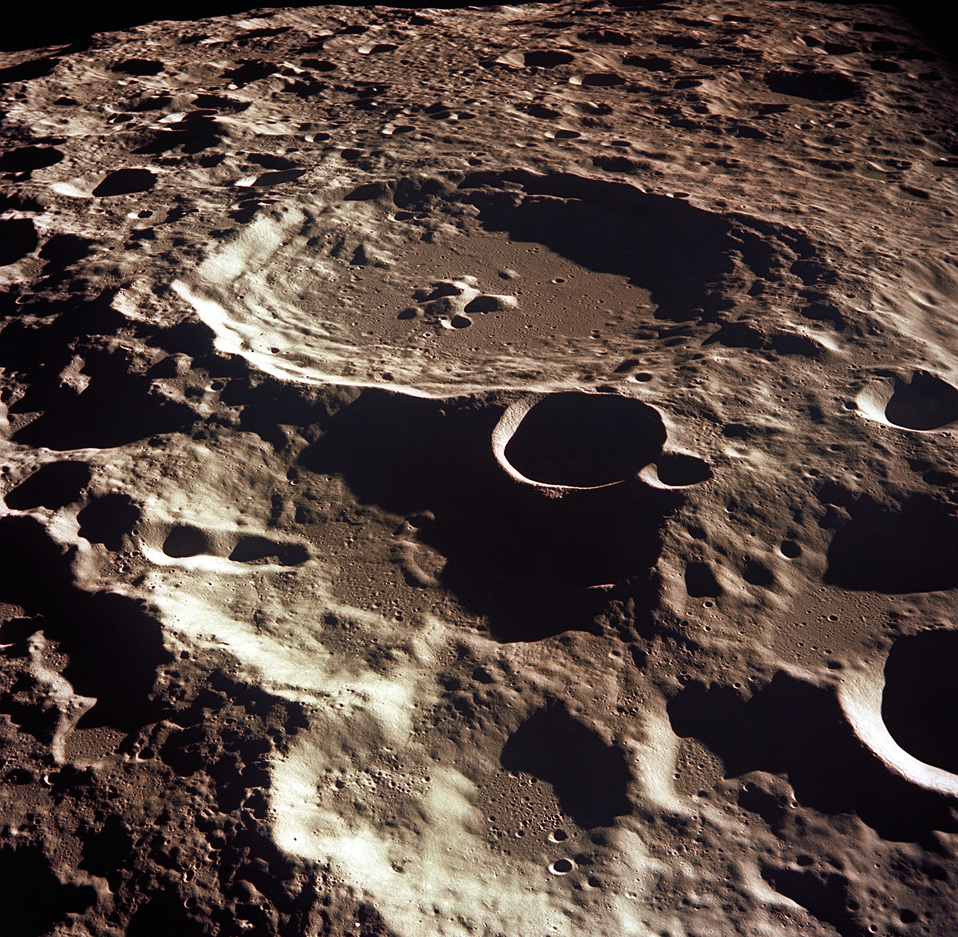 An aerial view of a large brown crater on the moon's farside