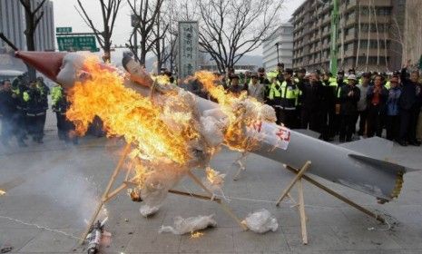 South Korean protesters burn a mockup of a North Korean missile during a protest against the North&amp;#039;s failed long-range rocket launch.