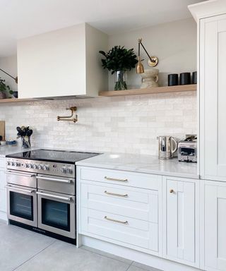 A white kitchen with glossy white kitchen backsplash ideas in tonal variations.