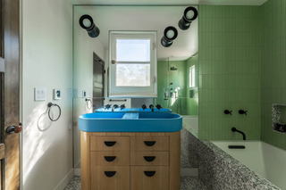 A bathroom with an analogous color palette of blue, green and yellow