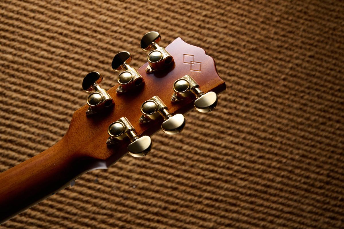 The Epiphone Inspired by Gibson Custom Hummingbird photographed in all its glory, in close-up and against a wheat-coloured rug.