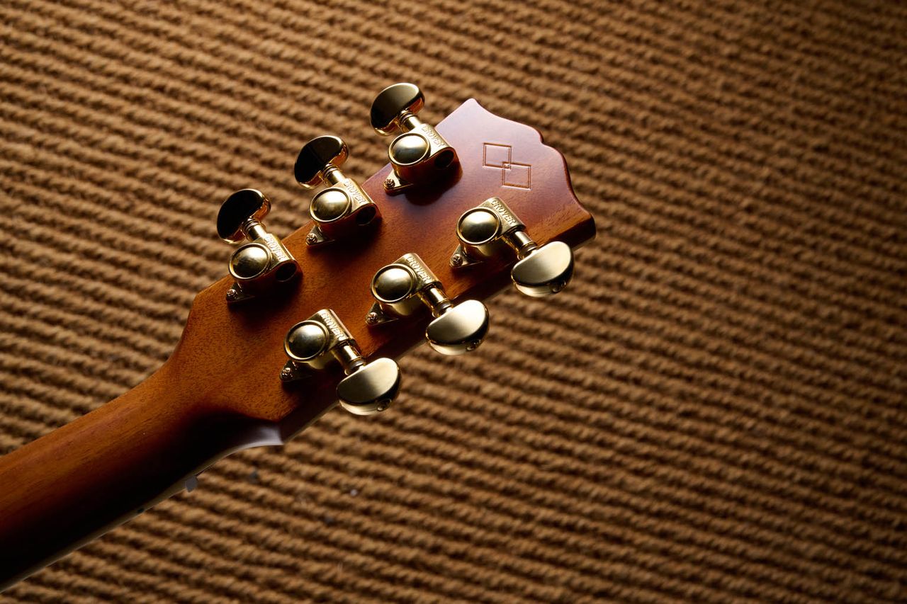 The Epiphone Inspired by Gibson Custom Hummingbird photographed in all its glory, in close-up and against a wheat-coloured rug.