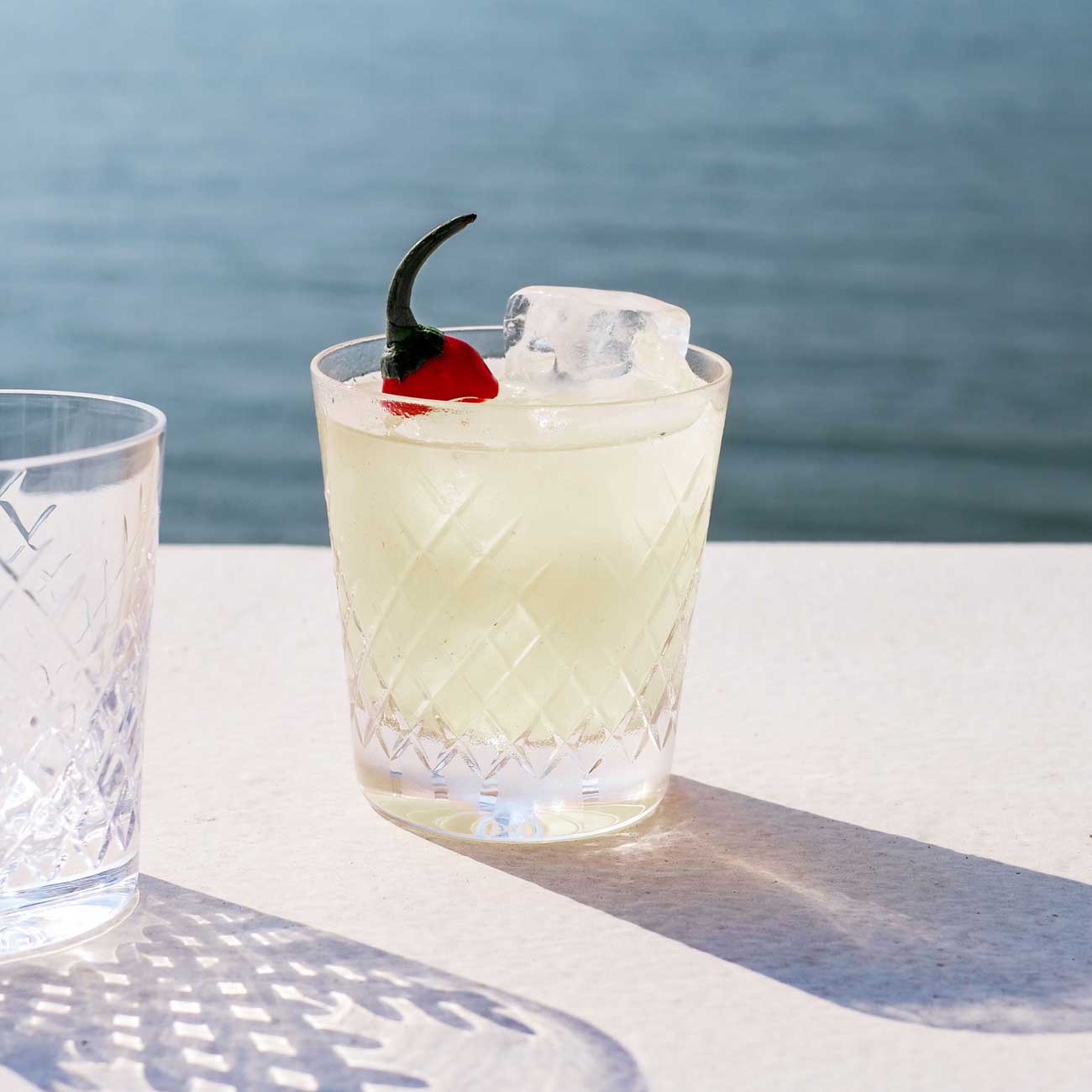 Picante de la Casa cocktail on a white bar by the sea