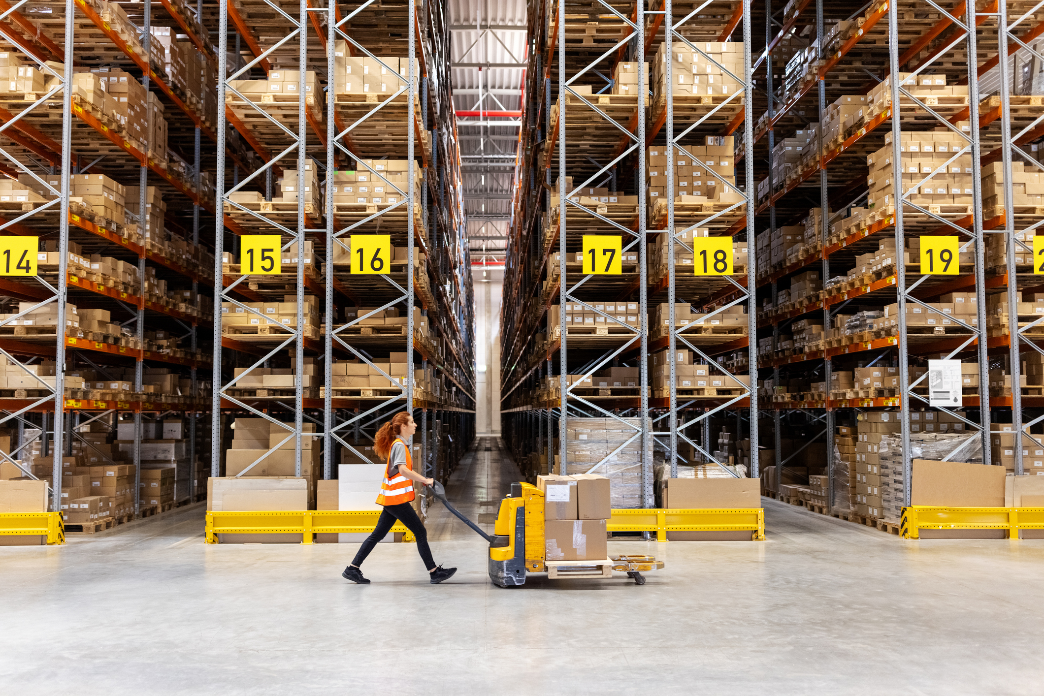 worker pushing a truck in a warehouse