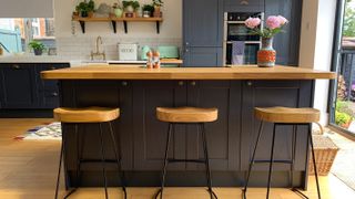 breakfast bar with wooden worktop and wooden bar stools