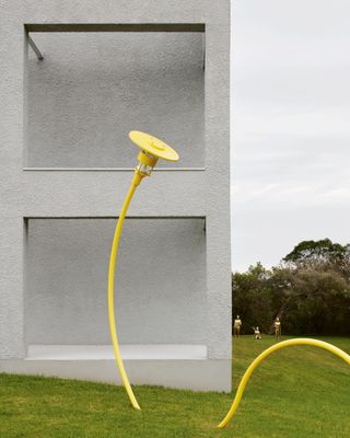 exterior of concrete house with lawn and large yellow sculpture