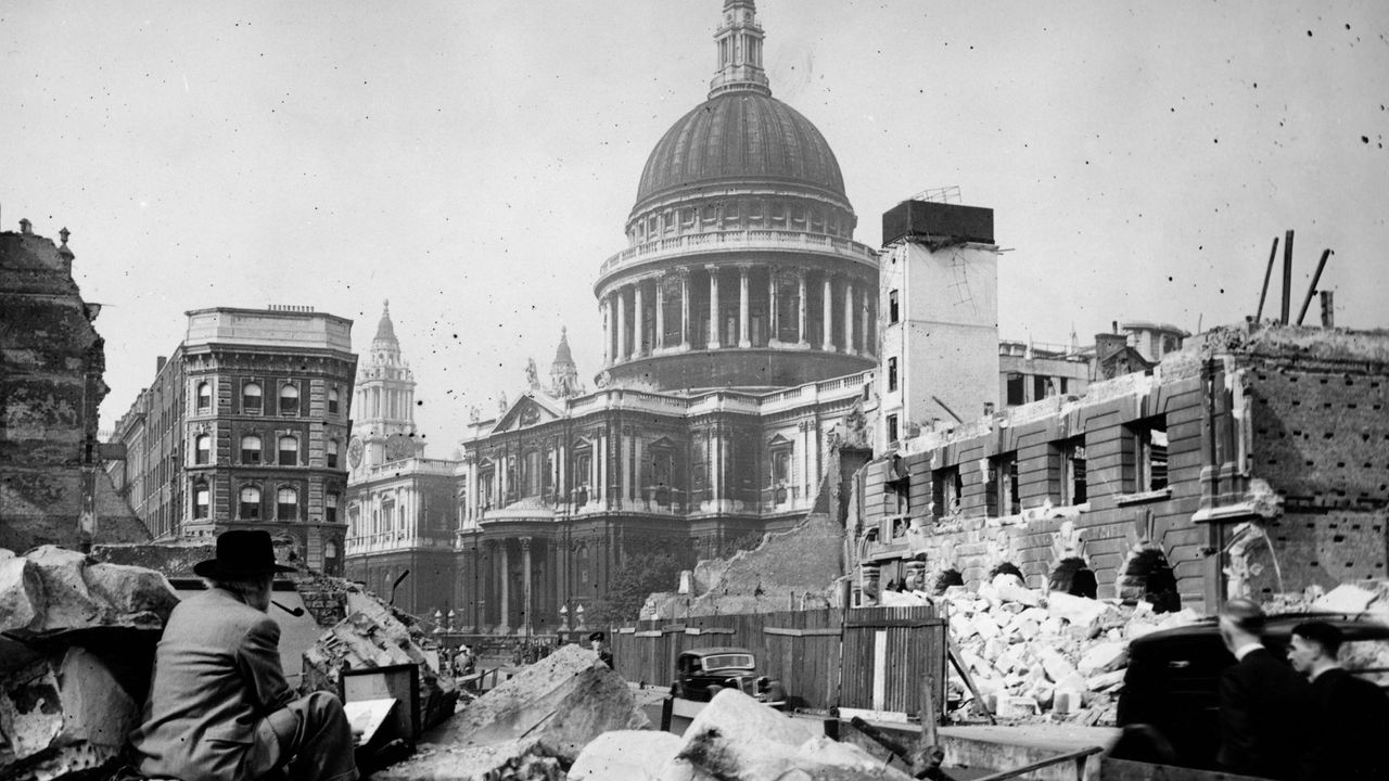 In WWII an artist sits in the rubble of a City of London street painting St Paul&#039;s Cathedral which is undamaged