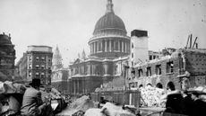 In WWII an artist sits in the rubble of a City of London street painting St Paul's Cathedral which is undamaged