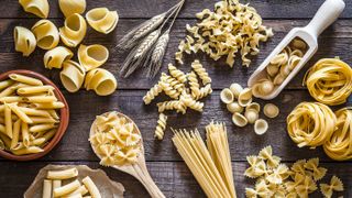 different types of pasta on wooden background