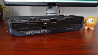 Gigabyte RTX 5070 Ti graphics card lying face down on woodgrain desk