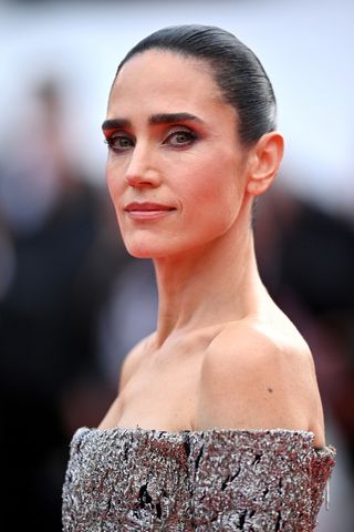 Jennifer Connelly attends the screening of "Top Gun: Maverick" during the 75th annual Cannes film festival, with a slicked back bun at Palais des Festivals on May 18, 2022 in Cannes, France.
