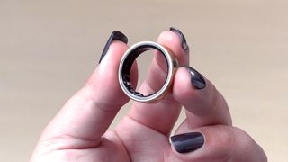 Samsung Galaxy Ring held between a person's fingers