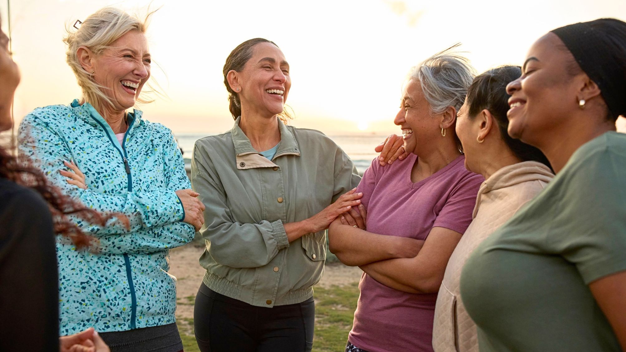 A group of women talking and laughing together at sunset