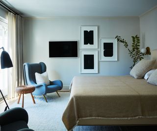 bedroom with black artworks and blue occasional chair