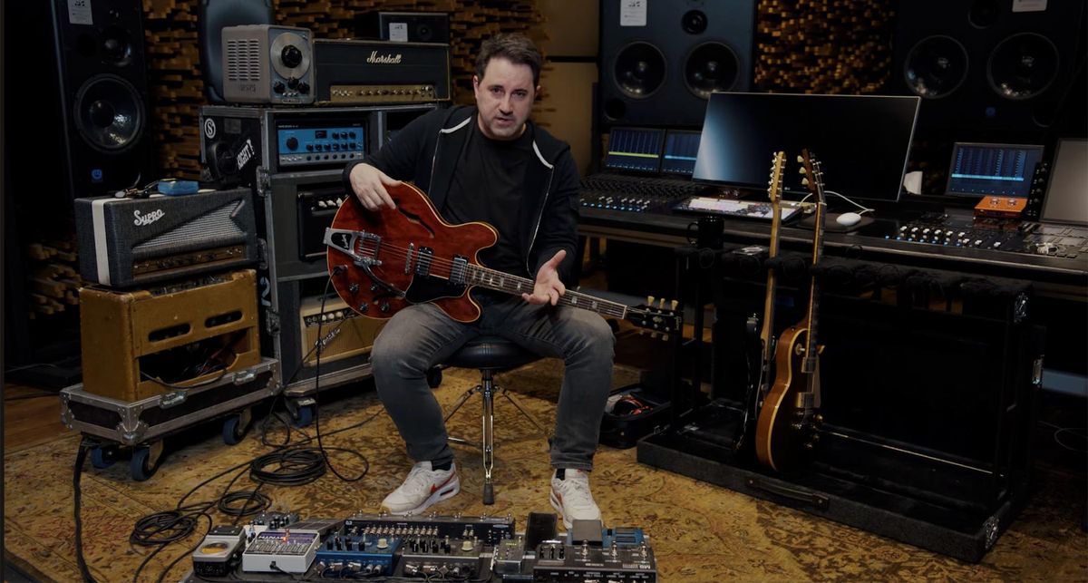 A video still of session pro Derek Wells in the studio with his pedalboard and ES-335